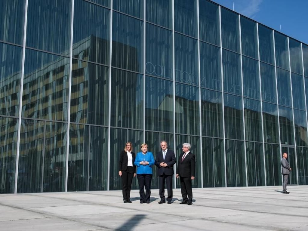 Claudia Perren (v.l.), Direktorin der Stiftung Bauhaus Dessau, Bundeskanzlerin Angela Merkel (CDU), Reiner Haseloff (CDU), Ministerpräsident von Sachsen-Anhalt, und Peter Kuras (FDP), Oberbürgermeister der Stadt Dessau-Rohlau, vor dem neuen Bauhaus Museum in Dessau. Foto: Hendrik Schmidt