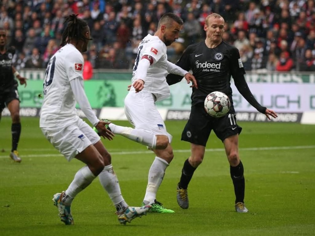 Der Berliner Vedad Ibisevic (M) und der Frankfurter Sebastian Rode (r) kämpfen um den Ball. Foto: Thomas Frey