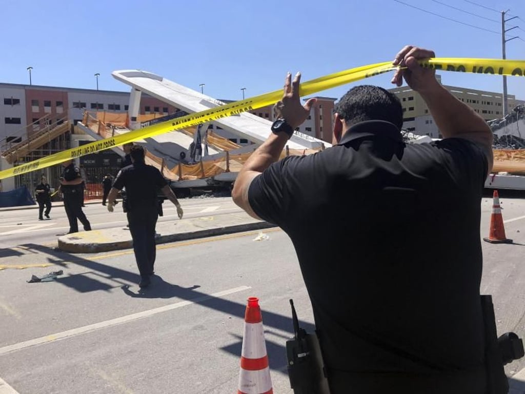 Rettungskräfte helfen an der Unfallstelle der eingestürzten Fußgängerbrücke. Foto: Andrea Cruz/WTVJ NBC6