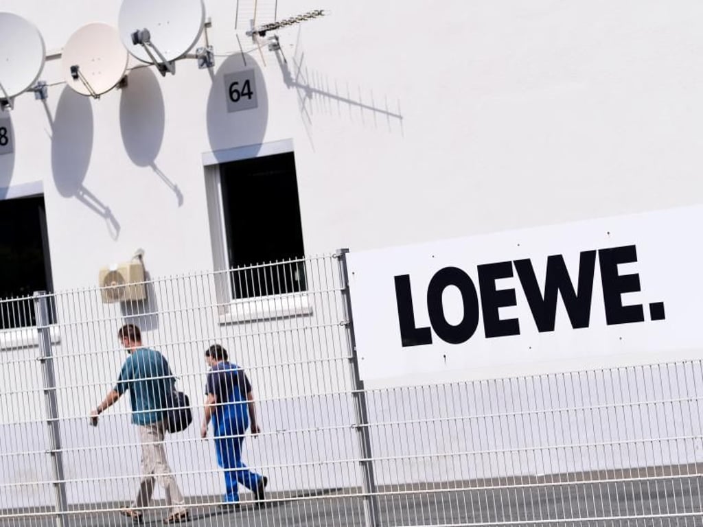 Zwei Mitarbeiter gehen über das Gelände des Elektronikherstellers Loewe AG. Das Unternehmen hatte Anfang Mai ein Insolvenzverfahren in Eigenverwaltung beantragt. Foto: David-Wolfgang Ebener