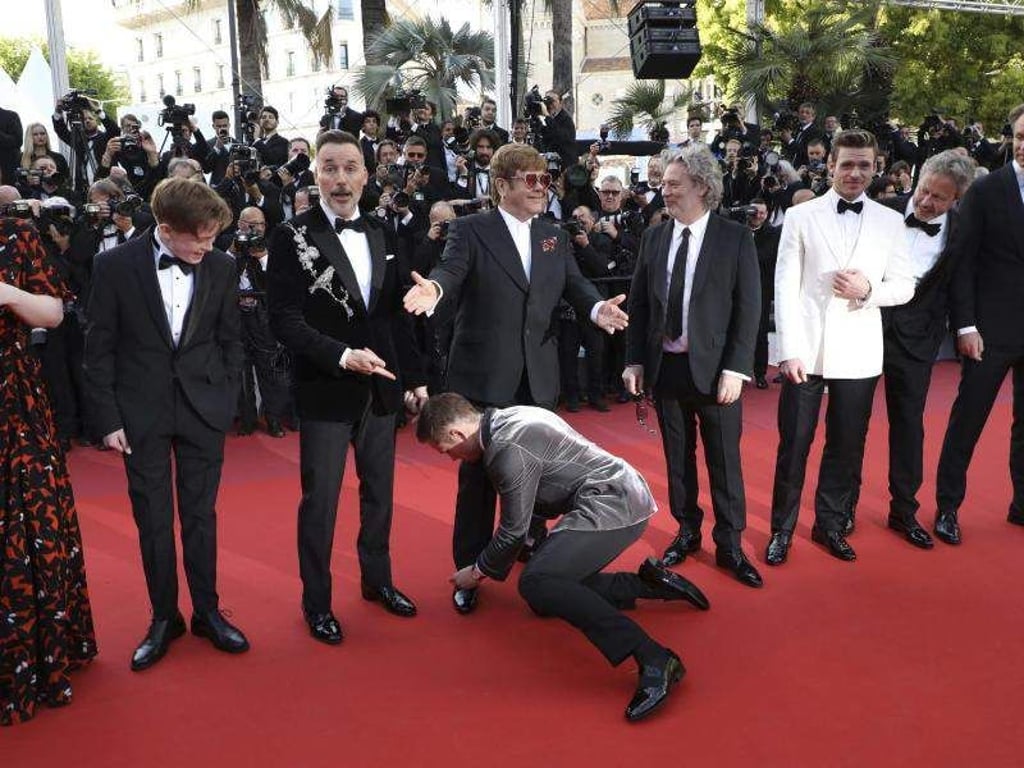 Fürsorglich: Taron Egerton bindet Elton John die Schnürsenkel. Foto: Vianney Le Caer/Invision/AP