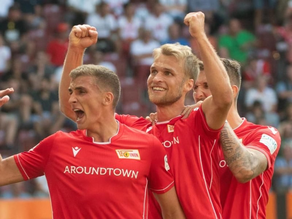 Grischa Prömel (l-r), Sebastian Andersson und Robert Andrich feiern das erste Union-Tor der Bundesliga-Geschichte. Foto: Stefan Puchner