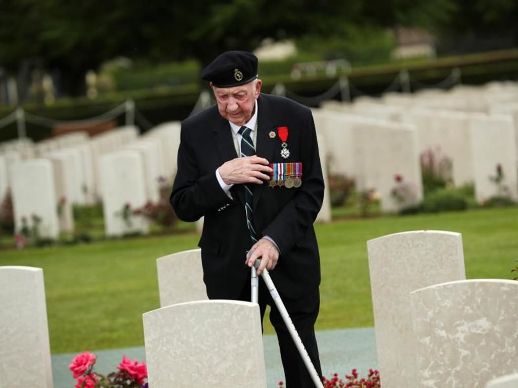 Ein Weltkriegsveteran bekreuzigt sich auf dem Soldatenfriedhof von Bayeux zum 75. Jahrestag des D-Day. Foto: Francisco Seco/AP