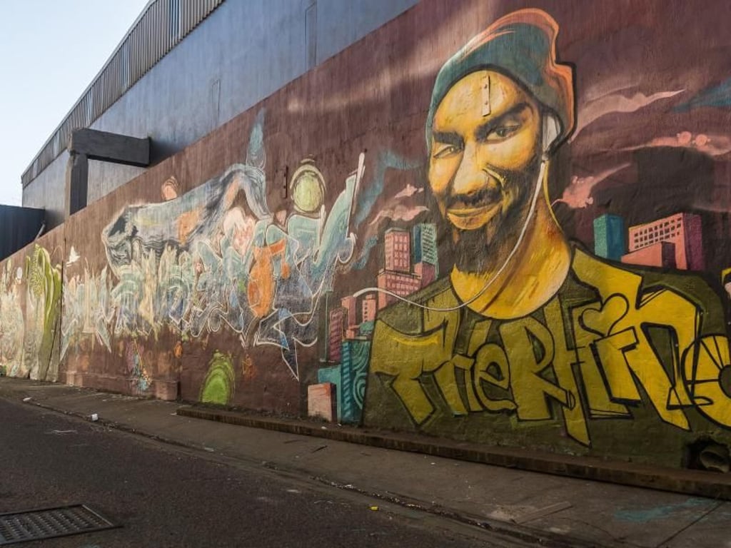 Ein Wandbild in River Town zeigt den verstorbenen Grafitti-Künstler Delon «4GIVN» Moody. Foto: Philipp Laage
