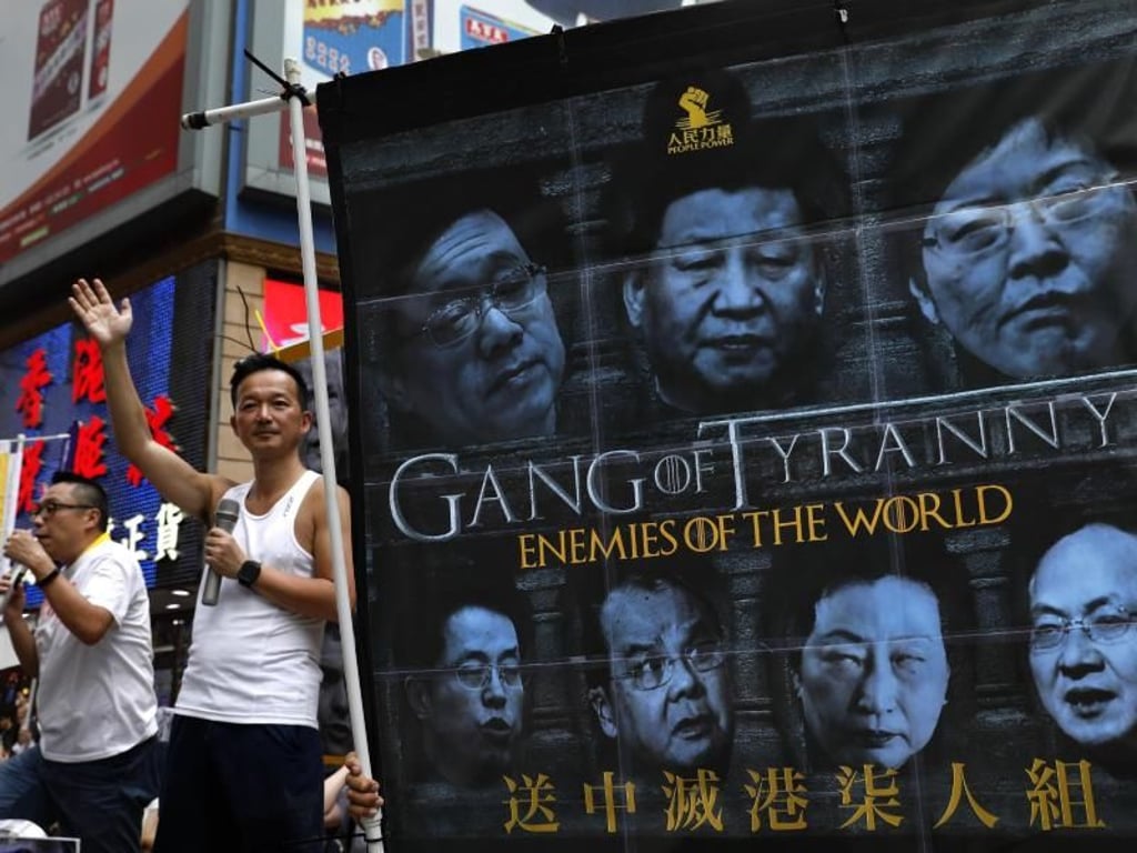 Demonstranten halten ein Banner, auf dem unter anderem der chinesische Präsident Xi (M) zu sehen ist, mit der Aufschrift «Game of Tyranny - Enemies of the World». Foto: Vincent Yu/AP