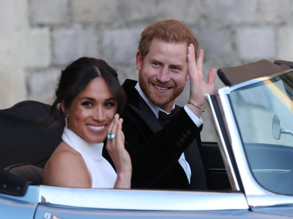 Der britische Prinz Harry und seine Frau Meghan auf der Fahrt zum Hochzeitsfest. Foto: Steve Parsons, PA Wire