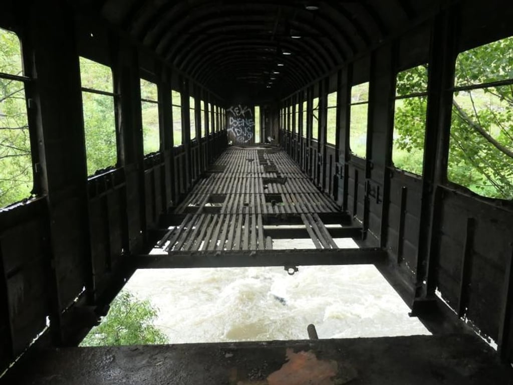 Wer diese Brücke überquert muss Mut haben. Das Innere des alten Eisenbahnwaggons wirkt mehr als desolat. Foto: Annette Meinke-Carstanjen