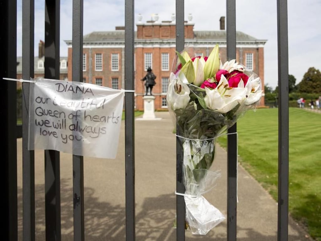 Am goldenen Tor des Kensington Palace hängen wenige Tage vor dem 20. Todestag von Prinzessin Diana Nachrichten und Blumen. Foto: Isabel Infantes