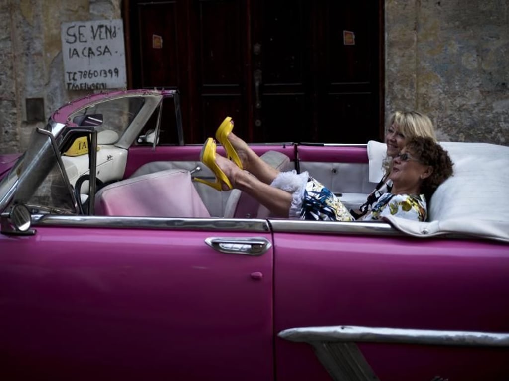 Zwei Frauen amüsieren sich in einem klassischen American Chevrolet. Foto: Ramon Espinosa/AP