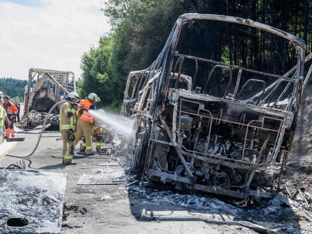 Das Buswrack wird von Feuerwehrleuten nachgelöscht. Foto: Matthias Balk