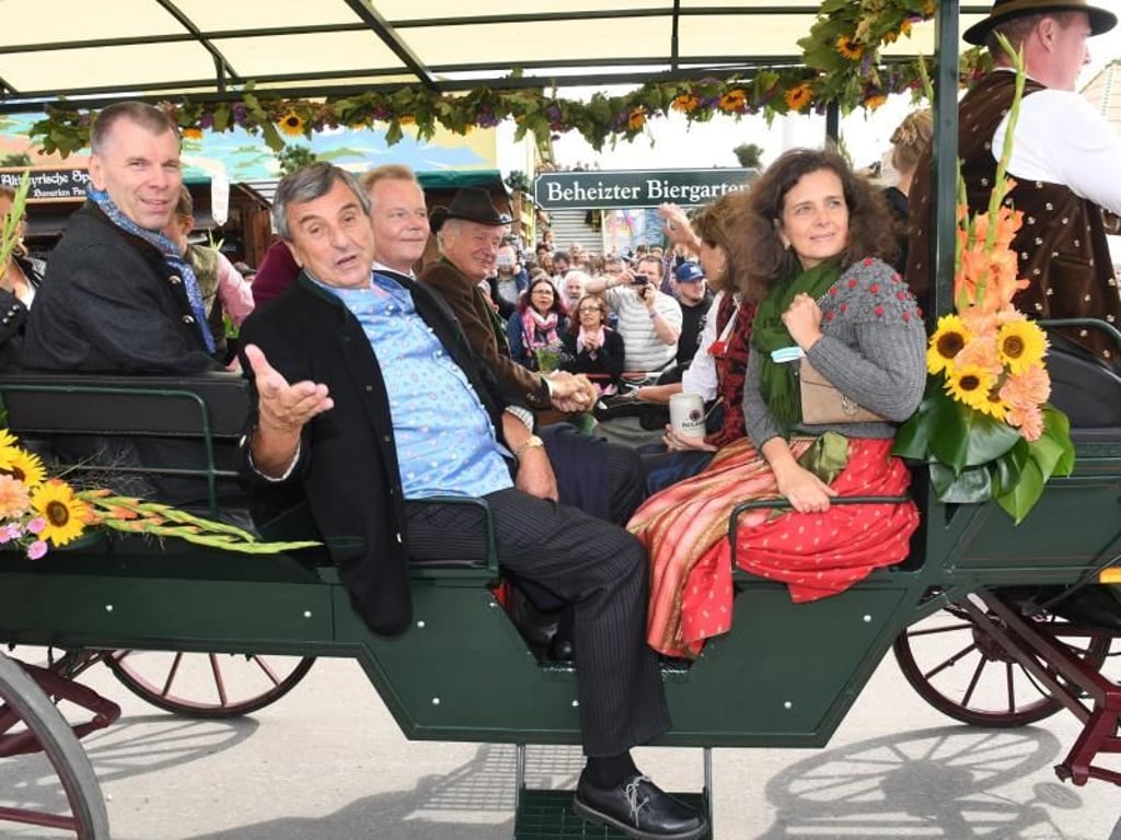 Die Wirtsleute Peter Pongratz (2.v.l) und Arabella Pongratz (r) fahren auf dem Oktoberfest beim Einzug der Wiesnwirte in einer Kutsche. Foto: Felix Hörhager