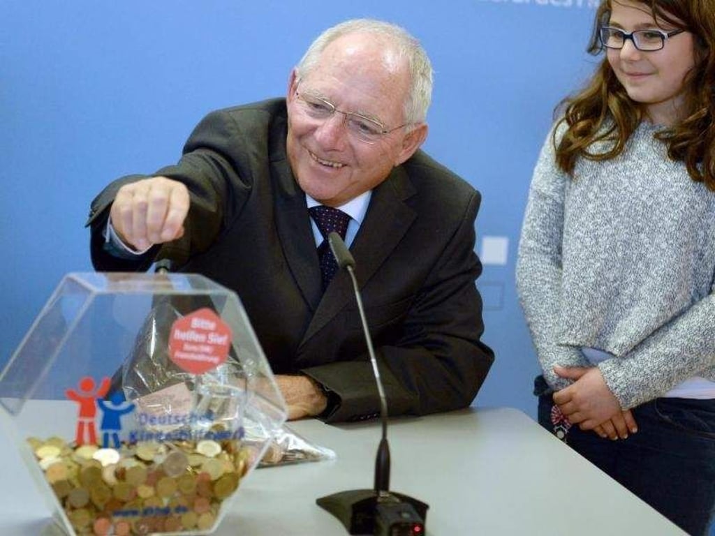 Wolfgang Schäuble wirft eine Münze in eine Spendenbox des Kinderhilfswerks: Der Bundesfinanzminister ruft die Deutschen dazu auf, ausländische Münzen zu spenden. Foto: Britta Pedersen