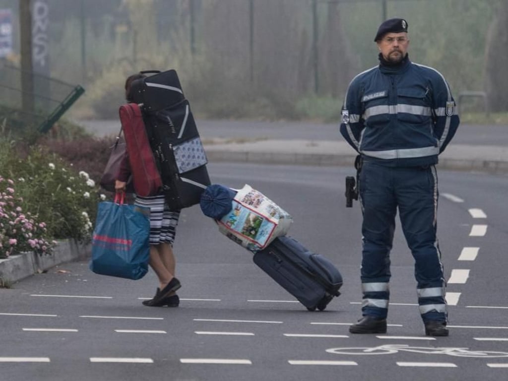 Eine Anwohnerin verlässt die Evakuierungszone. Foto: Boris Roessler