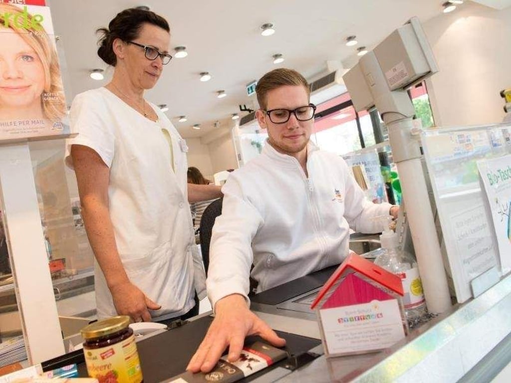 Zügig an der Kasse arbeiten: Auch das ist Teil von Anthonio Rätz' Ausbildung zum Drogisten. Er lernt in einer Filiale der dm-Drogeriekette in Berlin. Hier schaut ihm seine Ausbilderin Frau Kampa über die Schulter. Foto: Franziska Gabbert