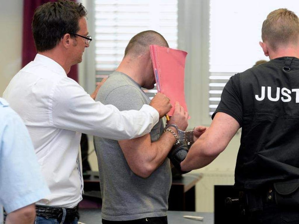 Einer der Angeklagten wird in den Saal des Landgerichts gebracht. Foto: Hendrik Schmidt/Archiv
