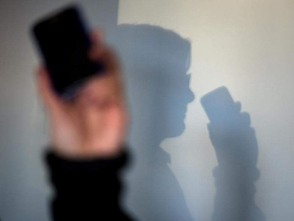 Eine Frau telefoniert mit ihrem Mobiltelefon. Foto: Arno Burgi/Archiv