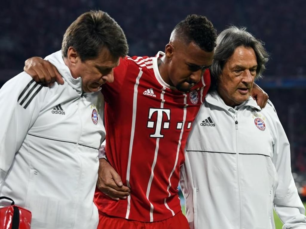 Der verletzte Jerome Boateng (M) wird vom Spielfeld geleitet. Foto: Andreas Gebert