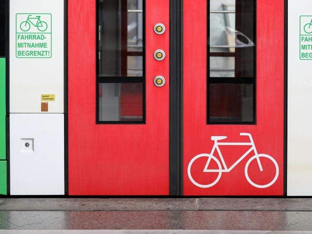 Ein Fahrradsymbol auf einer Zugtür und Schilder «Fahrradmitnahme begrenzt!» prangen auf einem Triebwagen im Hauptbahnhof. Foto: Jan Woitas