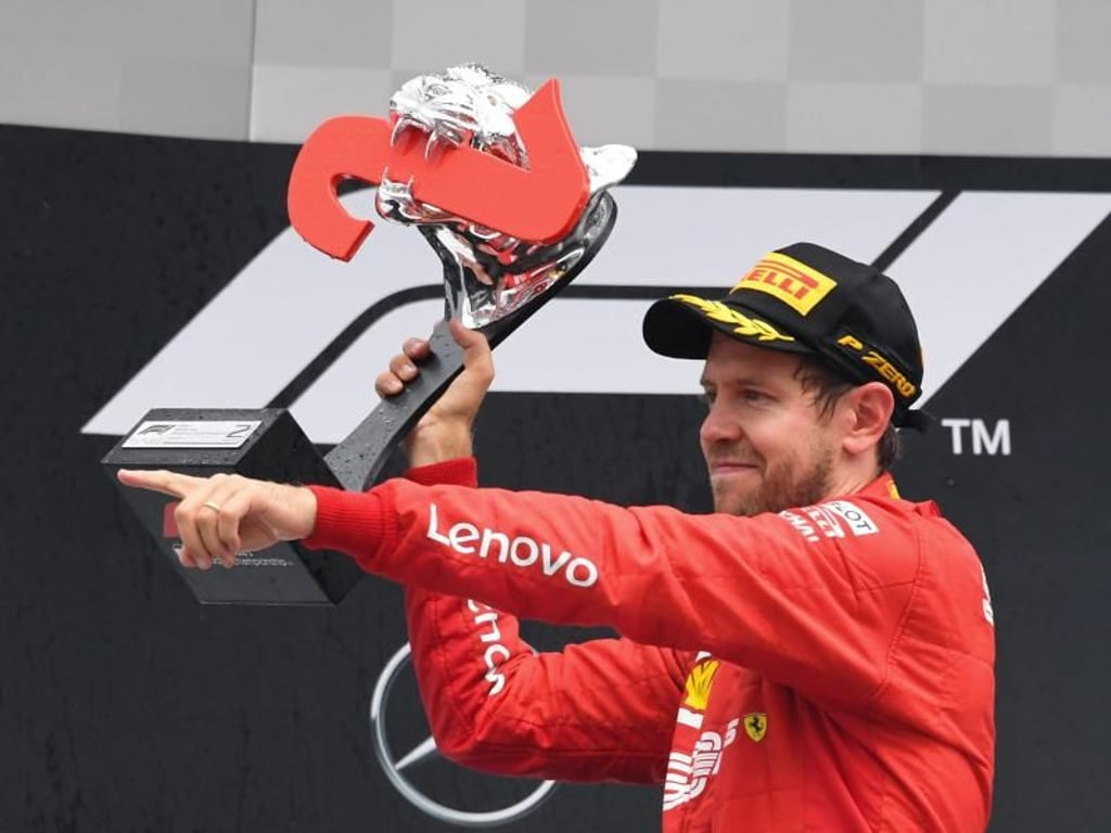 Vettel jubelt bei der Siegerehrung mit der Trophäe. Foto: Uli Deck