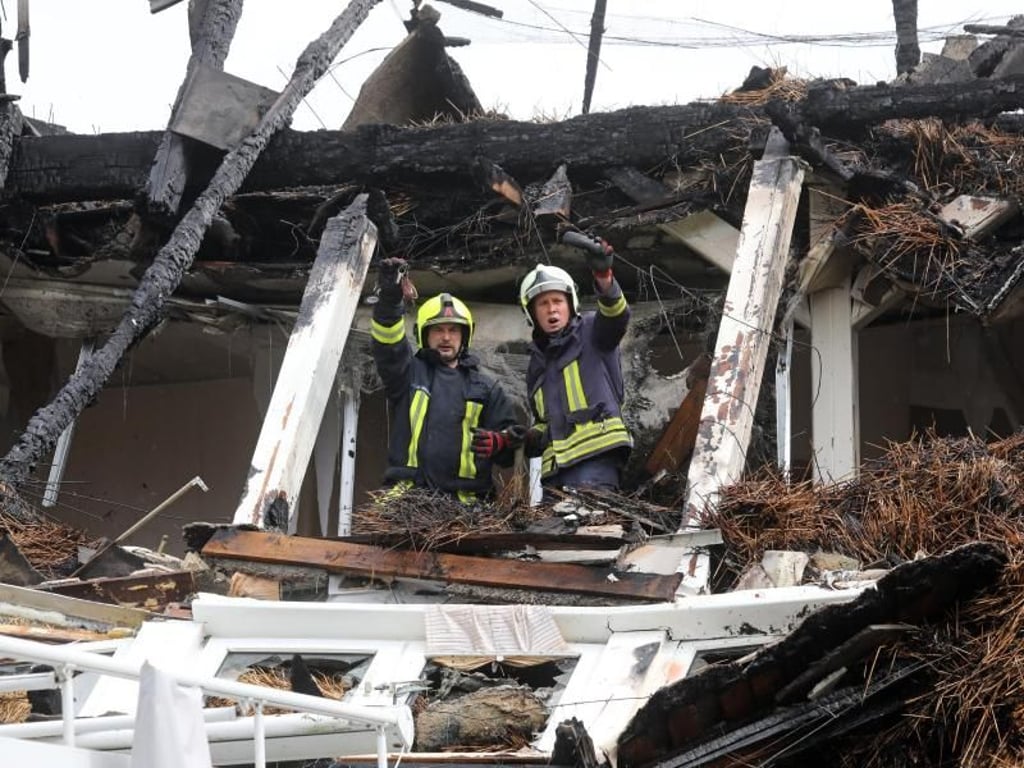 Feuerwehrmann suchen im Dachstuhl des ausgebrannten Ostseehotels auf der Halbinsel Fischland-Darß-Zingst nach Habseligkeiten der Hotelbewohner. Foto: Bernd Wüstneck