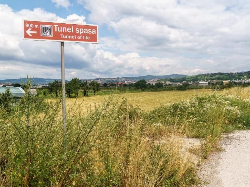 Südlich des Flughafens von Sarajevo spaziert der Besucher durch Vorort-Idylle. Ein Schild weist den Weg zum Tunnel-Museum. Foto: Philipp Laage/dpa-tmn