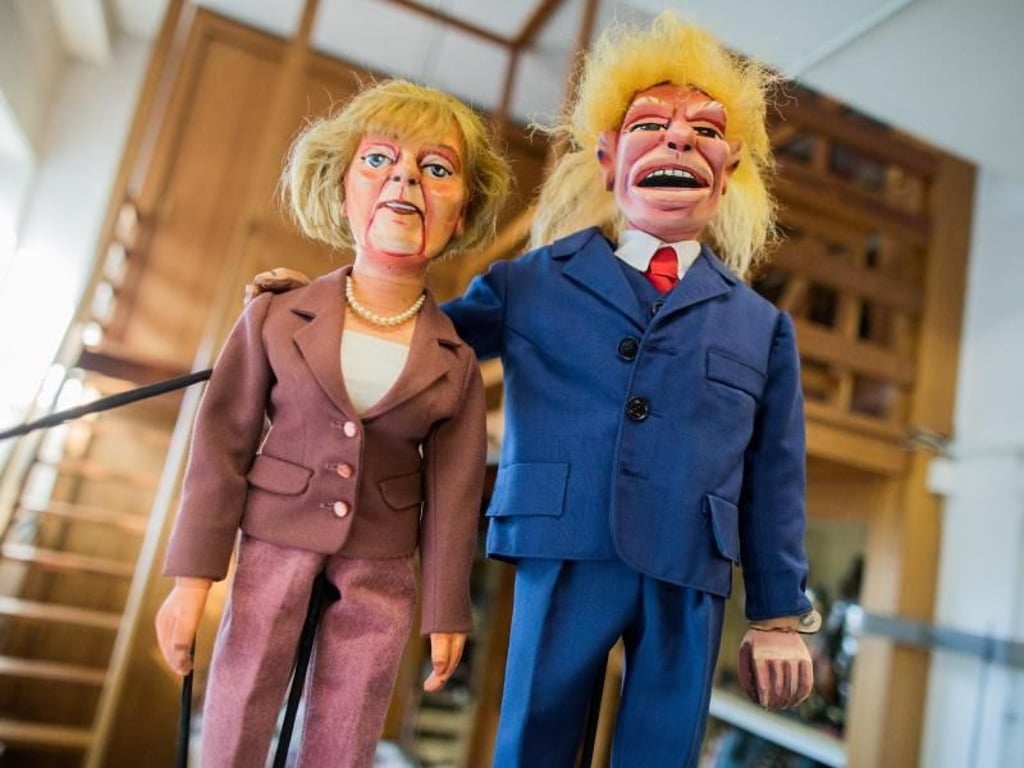 Zwei Stockpuppen, die Bundeskanzlerin Angela Merkel und Donald Trump darstellen sollen. Foto: Rolf Vennenbernd