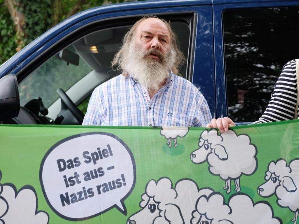 Lothar König, Pfarrer aus Jena, steht bei einer Kundgebung hinter einem Transparent. Foto: Sebastian Willnow/Archivbild