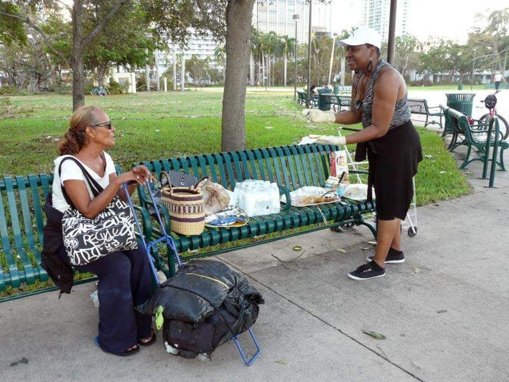 Yanick Landess (r) verteilt am Tag nach dem Hurrikan "Irma" an der Promenade in Miami (USA) Sandwiches, Chipstüten und Wasser an Bedürftige. Foto: Saskia Fröhlich/Archiv