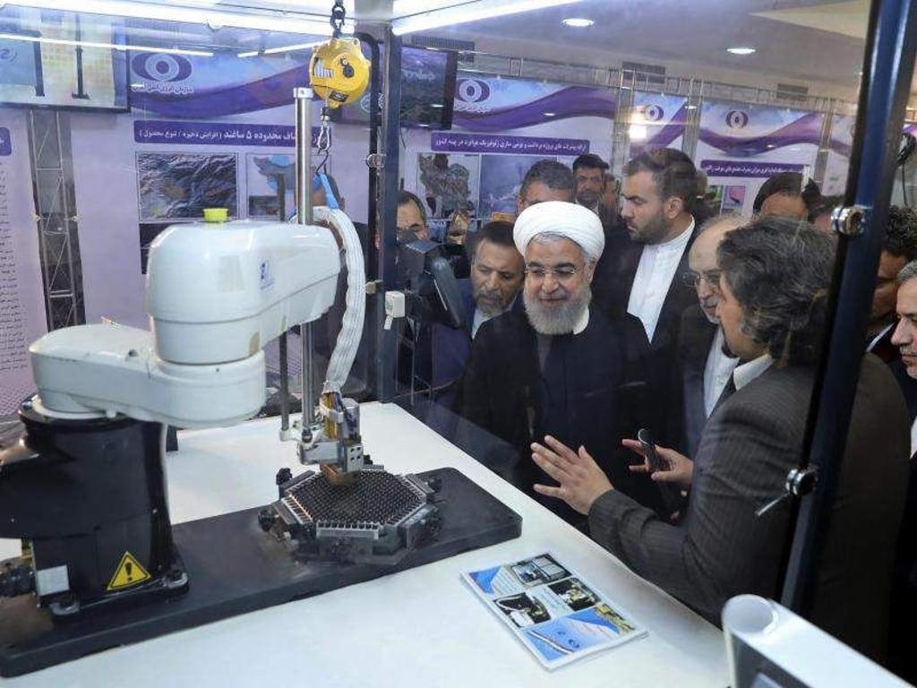Irans Präsident Hassan Ruhani (M.) lässt sich neue Entwicklungen in der Atomenergie im Rahmen des «Nationalen Atomtags» erklären. Foto: Iranian Presidency Office/AP