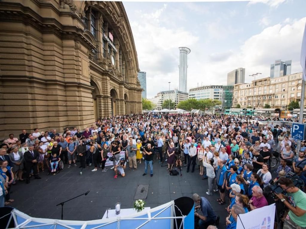 Menschen stehen während einer Trauerandacht vor dem Frankfurter Hauptbahnhof. Foto: Andreas Arnold