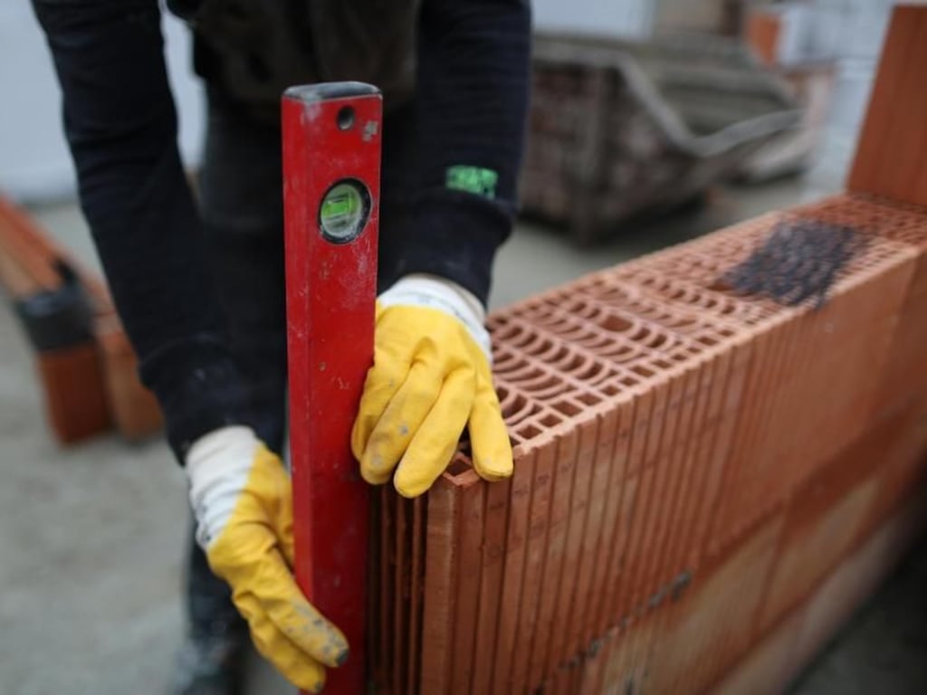 Eine schiefe Wand braucht niemand: Maurer kontrollieren bei der Arbeit immer wieder sorgfältig, ob alles nach Plan läuft. Foto: Ina Fassbender