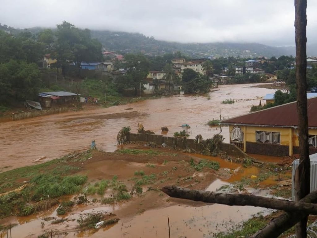 Wasser strömt durch eine Straße im Regent-Distrikt. In einigen Bezirken fiel der Strom aus, als unterspülte Leitungsmasten wegbrachen. Foto: Manika Kamara