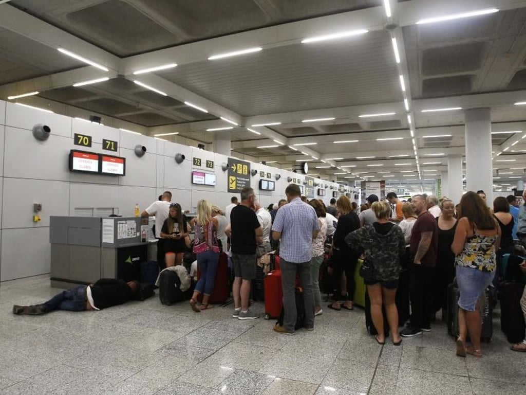 Gestrandete Urlauber stehen in einer Schlange am Flughafen von Palma de Mallorca. Foto: Isaac Buj/Europa Press