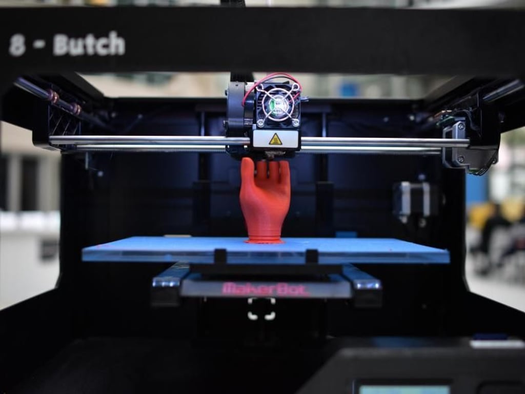 Ein 3D-Drucker zaubert eine rote Hand hervor. Foto: Christian Platz