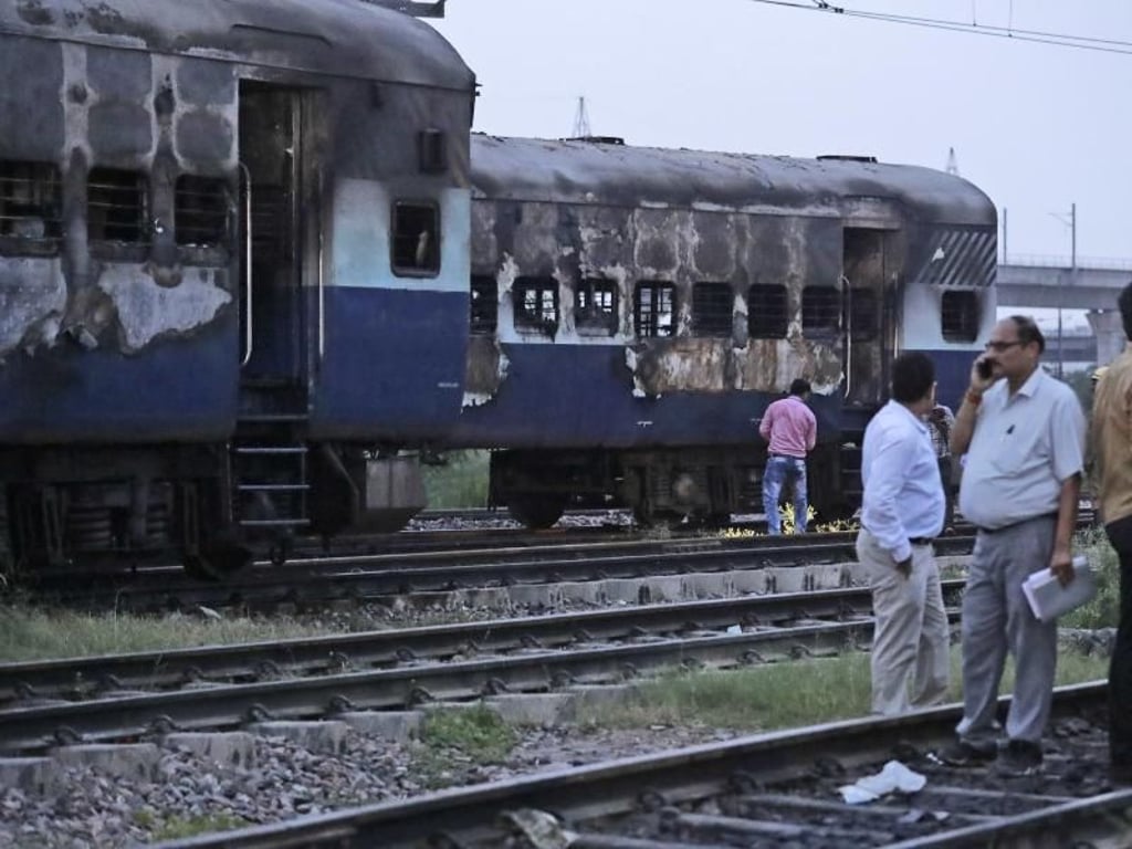 Ein Zug, der bei den Ausschreitungen in Neu Delhi (Indien) ausbrannte. Foto: Manish Swarup