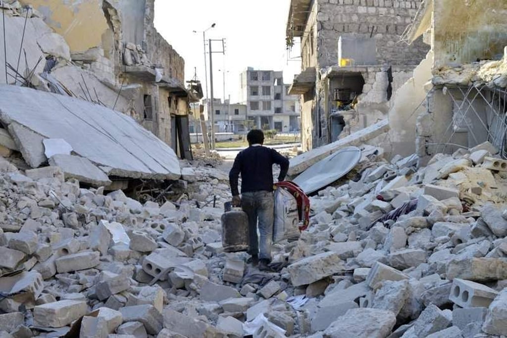 epa04099671 A photo made available on 25 February 2014 shows a man carrying belongings he recovered after his home was allegedly hit by a government launched barrel bomb attack in Tariq al Bab neighborhood, Aleppo, Syria, 17 February 2014. The UN Security Council unanimously passed a resolution on 22 February demanding humanitarian access and ending violence against civilians in Syria. The draft also demands that all parties stop shelling and aerial bombardments, which lead to large numbers of civilian injuries, and specifically calls for ending the use of barrel bombs, large containers filled with explosives and shrapnel usually dropped from helicopters by the Syrian army. EPA/ALI MUSTAFA +++(c) dpa - Bildfunk+++
