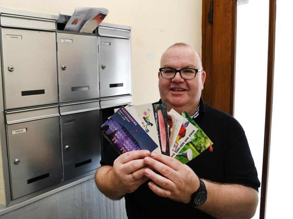 Postcrosser Sven van Kempen mit einem Schwung Postkarten aus seinem Briefkasten. Foto: Ina Fassbender