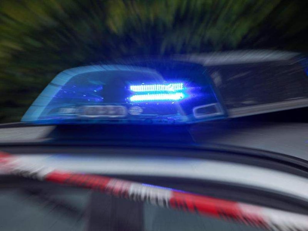 Das Blaulicht eines Polizeiautos mit Absperrband im Vordergrund. Foto: Daniel Karmann/Archiv