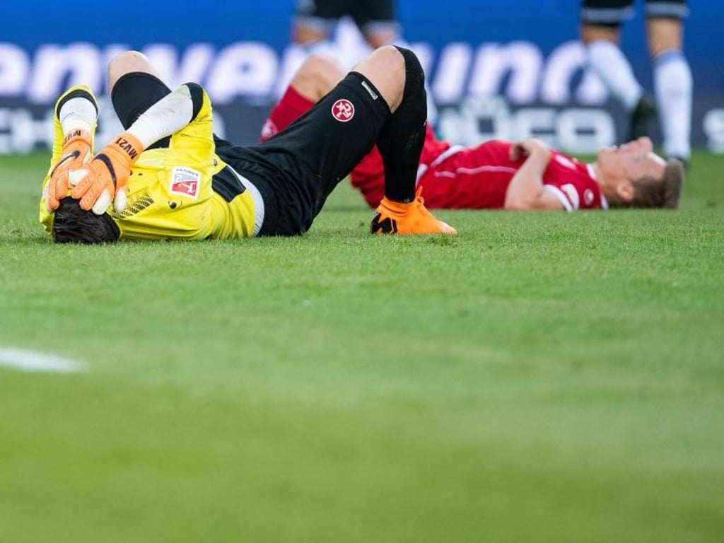Spieler vom 1. FC Kaiserslautern liegen nach dem Spiel enttäuscht auf dem Rasen. Foto: Guido Kirchner