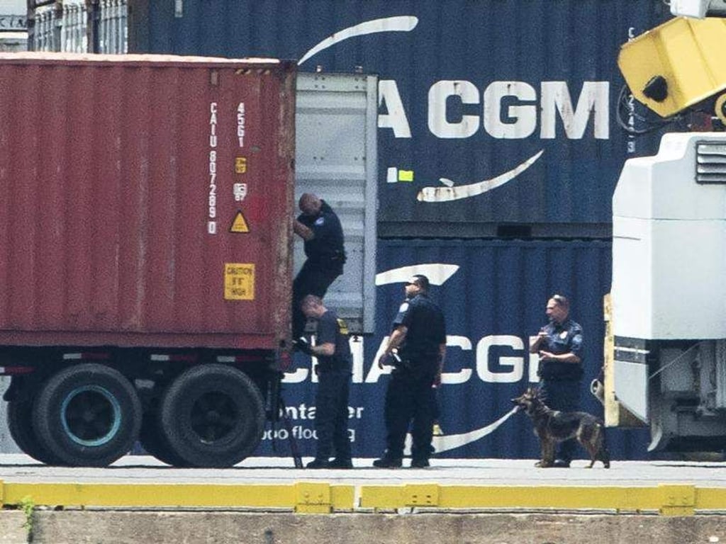 Mit einem Hund inspizieren Polizisten einen Container im Hafen von Philadelphia. Rund 15 Tonnen Kokain im Wert von mehr als einer Milliarde US-Dollar haben die Ermittler sichergestellt. Foto: Matt Rourke/AP