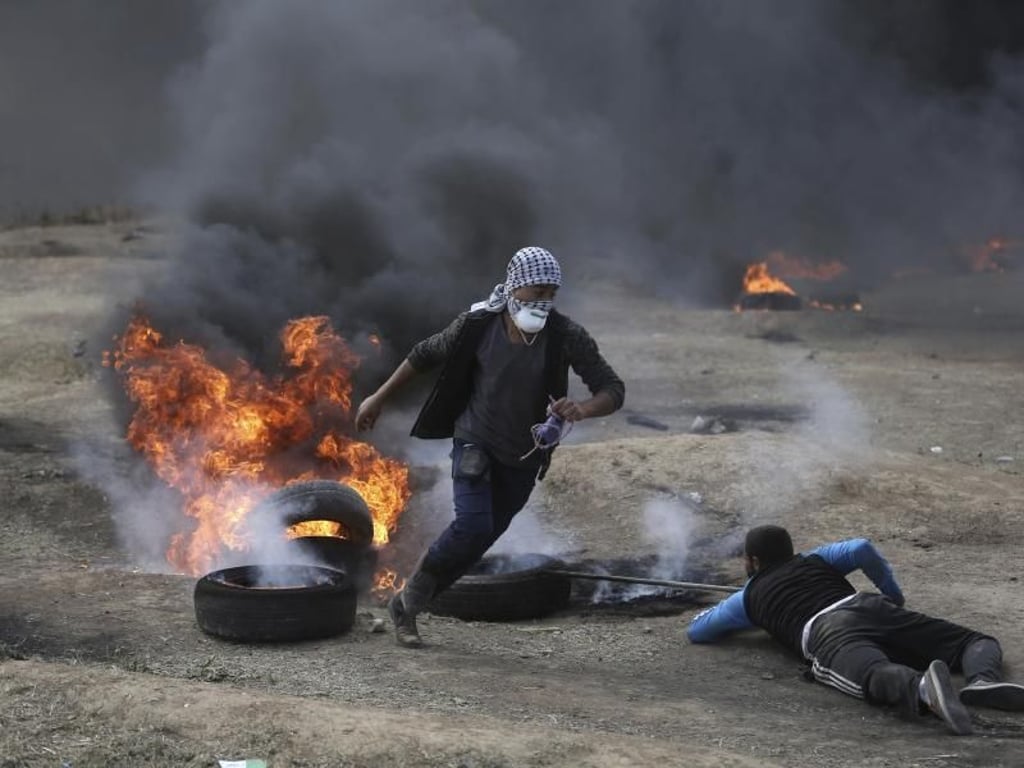 Palästinenser verbrennen Reifen bei Protesten in Gaza. Foto: Khalil Hamra, AP