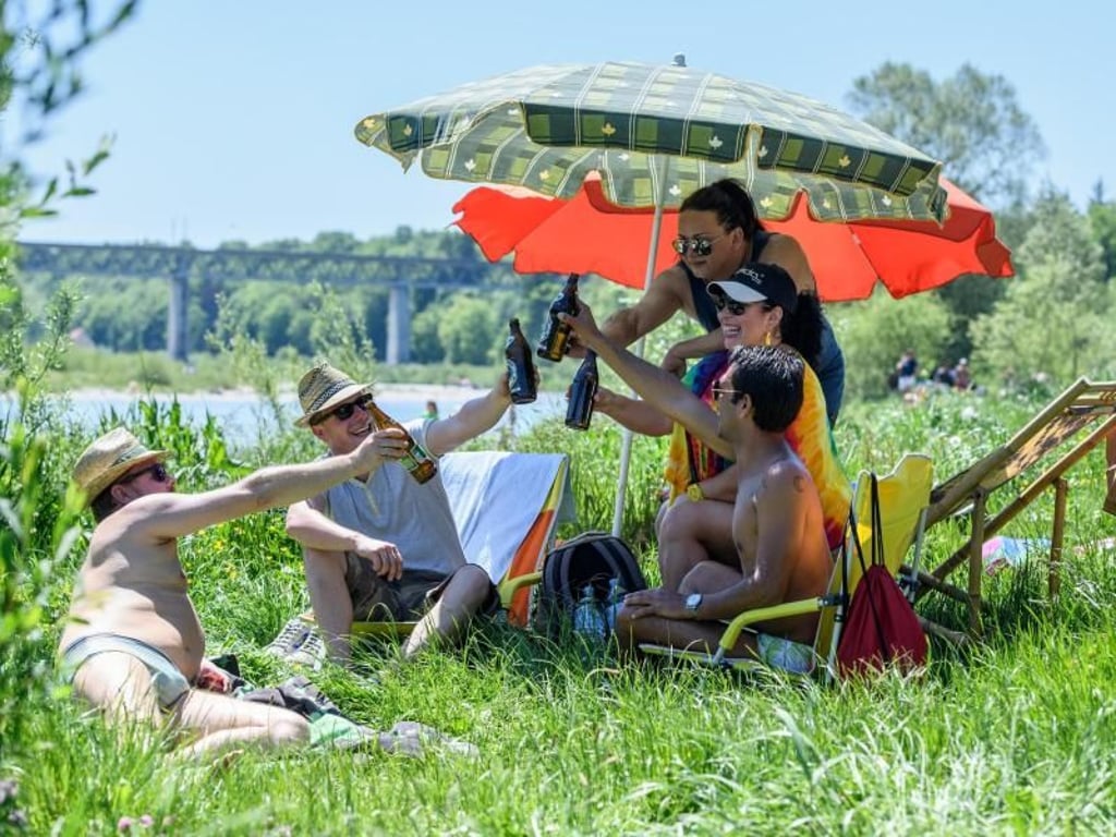 Prost! Ausflügler lassen sich an der Isar in München ihr Helles schmecken. Foto: Matthias Balk