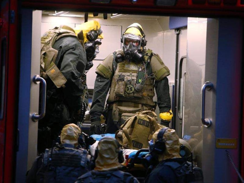 SEK-Beamten mit Atemschutzmasken und Schutzanzügen stehen in einem Fahrzeug vor einem Wohnkomplex. Der in Köln verhaftete Tunesier soll seine Vorbereitungen für einen Terroranschlag mit hochgiftigem Rizin bereits weitgehend abgeschlossen haben, als die Polizei zuschlug. Foto. David Young Foto: David Young
