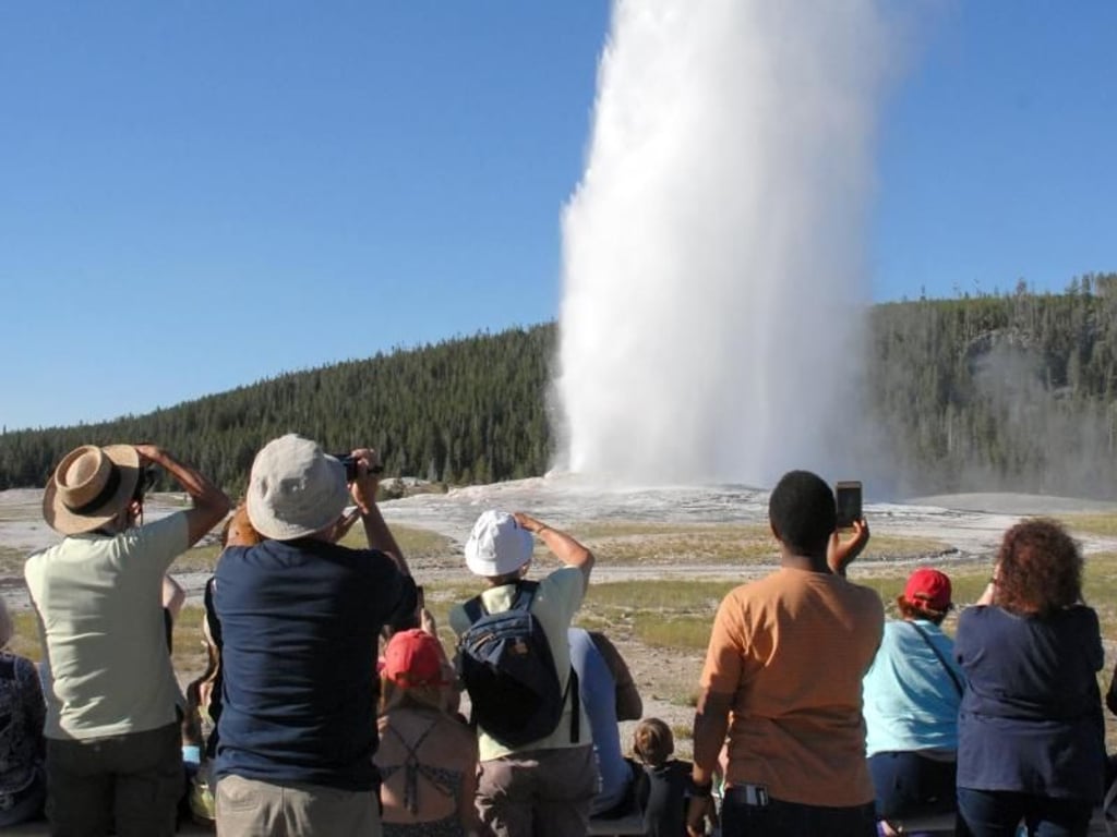 Da der Geysir Old Faithful so verlässlich Wasser in die Höhe schleudert, ist er von Touristen oft dicht umlagert. Foto: Christian Röwekamp