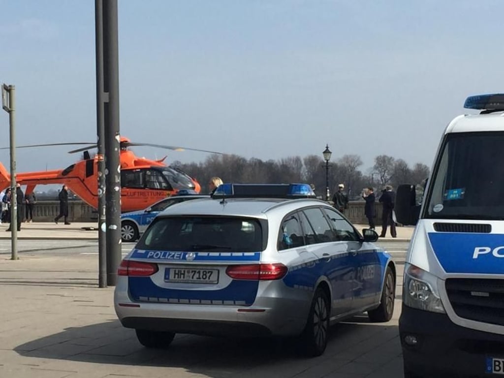 Einsatzfahrzeuge der Polizei und ein Rettungshubschrauber stehen am Jungfernstieg. Foto: Eckart Gienke