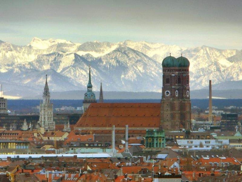 Die Münchener Frauenkirche vor den schneebedeckten Alpen. Foto: Peter Kneffel