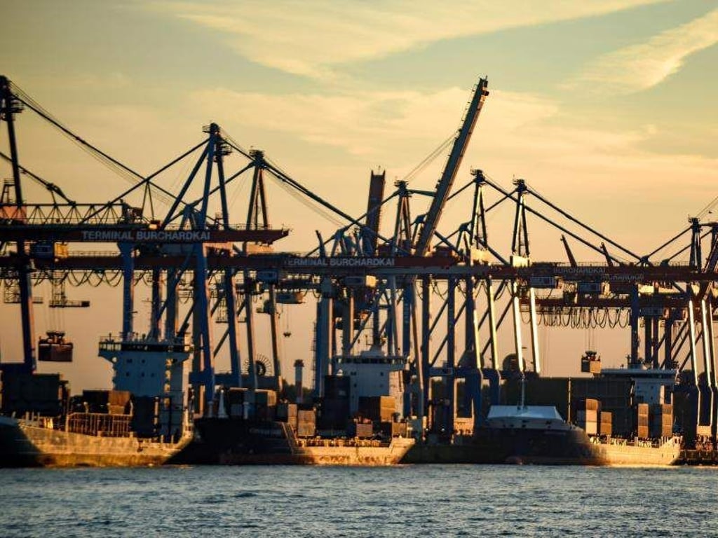 Containerschiffe werden im Hafen bei untergehender Sonne abgefertigt. Deutschland ist laut einer Untersuchung des bayerischen Unternehmerverbands vbw eines der Länder mit den besten Bedingungen für Industrieunternehmen weltweit. Foto: Axel Heimken