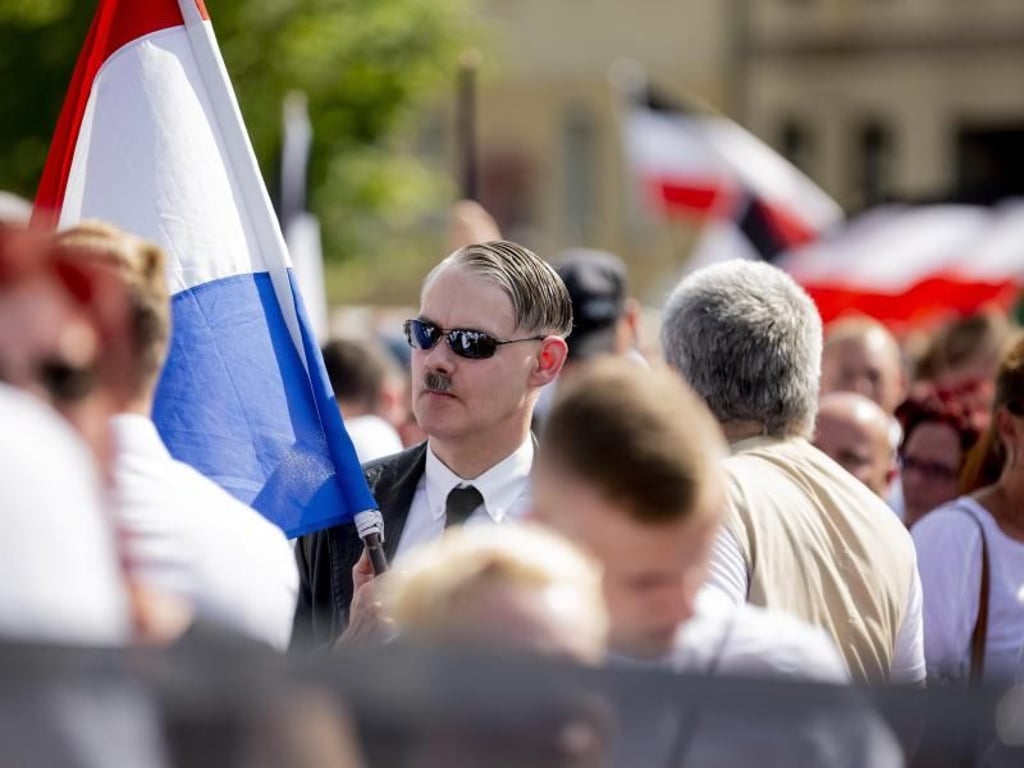 Mit Hitlerbart: Ein Teilnehmer der Neonazi-Demonstration anlässlich des 31. Todestages von Rudolf Heß. Foto: dpa