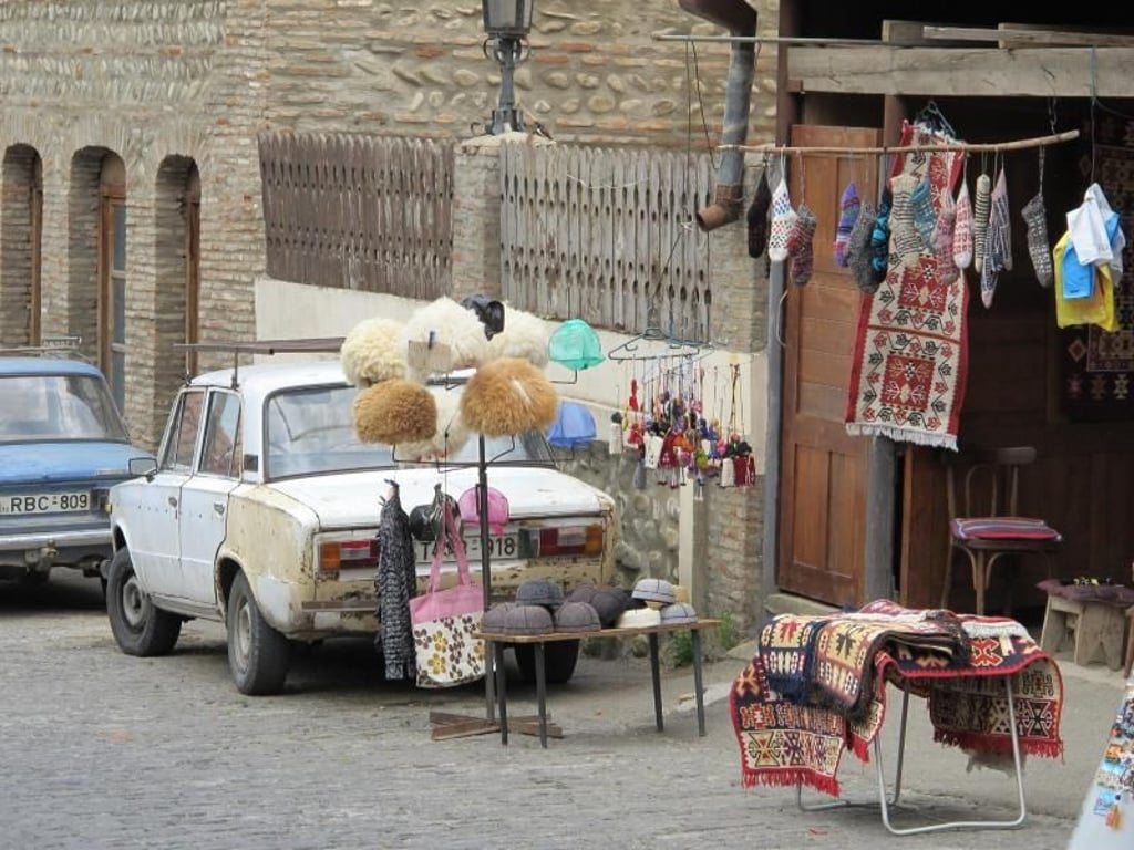Straßenszene in Sighnaghi: Die landestypischen Schafsfellmützen, die hier verkauft werden, sind bei Touristen beliebt. Foto: Annette Meinke-Carstanjen