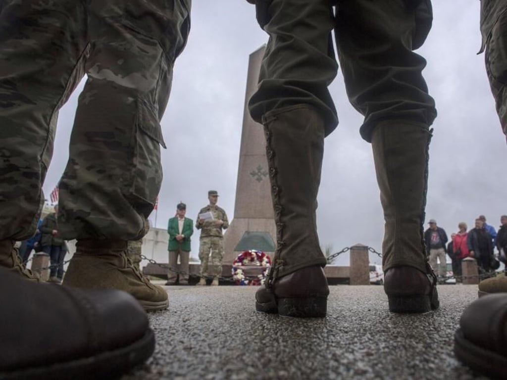US-Soldaten und Besucher stehen an einem Denkmal an einem Strand, der bei der Landung der Alliierten den Decknamen «Utah Beach» bekam. Foto: Rafael Yaghobzadeh/AP